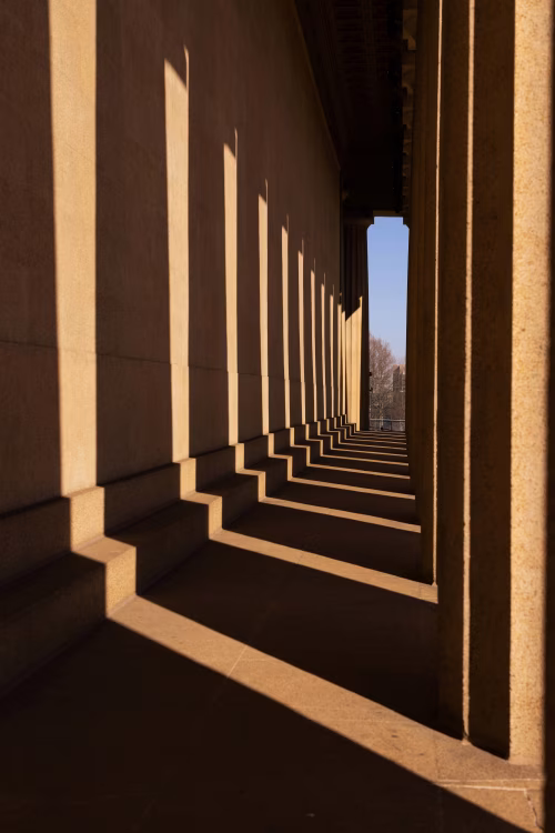 Shadow Patterns Across Classical Architectural Columns at Sunset