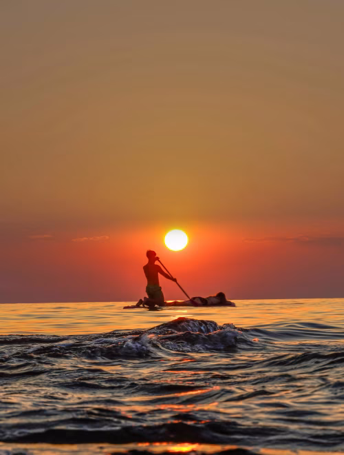 Silhouette of Paddler on Calm Ocean at Sunset