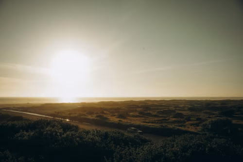 Sunlit Coastal Landscape with Road Overlooking Ocean Horizon at Sunrise