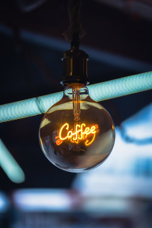 Vintage Light Bulb with Neon Coffee Sign in a Cozy Ambiance