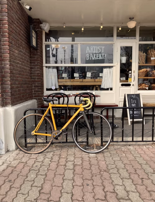 Yellow Bicycle Against Modern Street Bakery Exterior with Brick Details